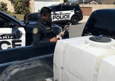 A Santa Maria Police Officer inspects an object to determine if it's a replica or real firearm