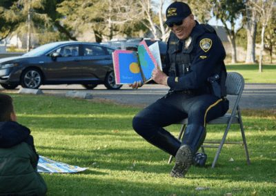 A Santa Maria Police Officer reads a book to school children