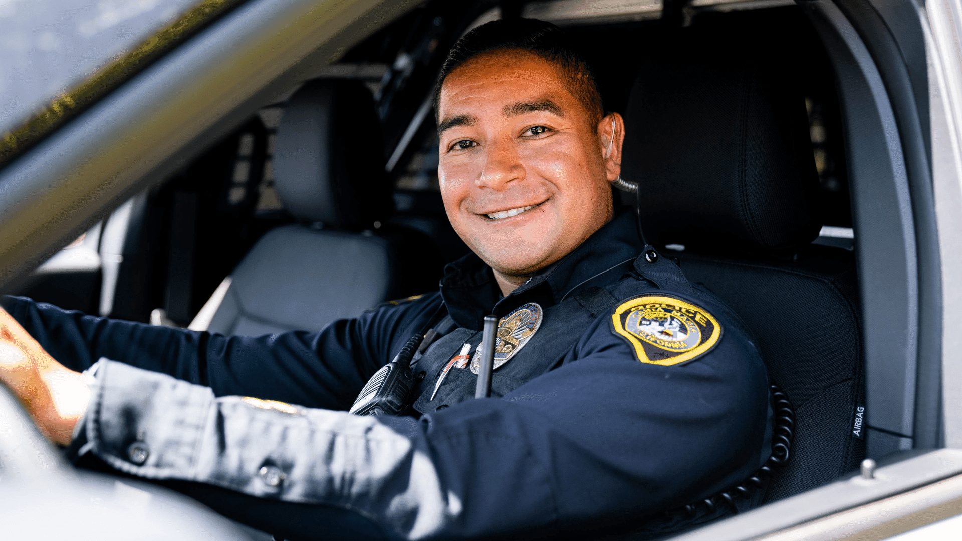 Santa Maria Police Officer Jesus Caro poses for a photo while seated in his patrol vehicle